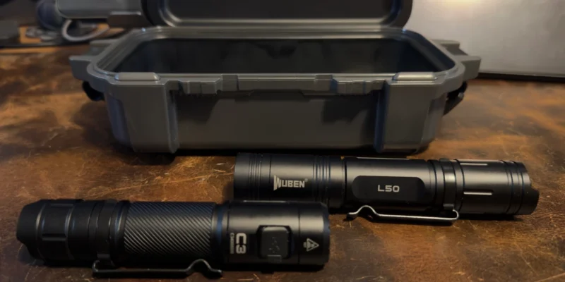 Wuben C3 and Wuben L50 EDC flashlights side by side in front of a Yeti Gearbox showing the size difference between the two lights