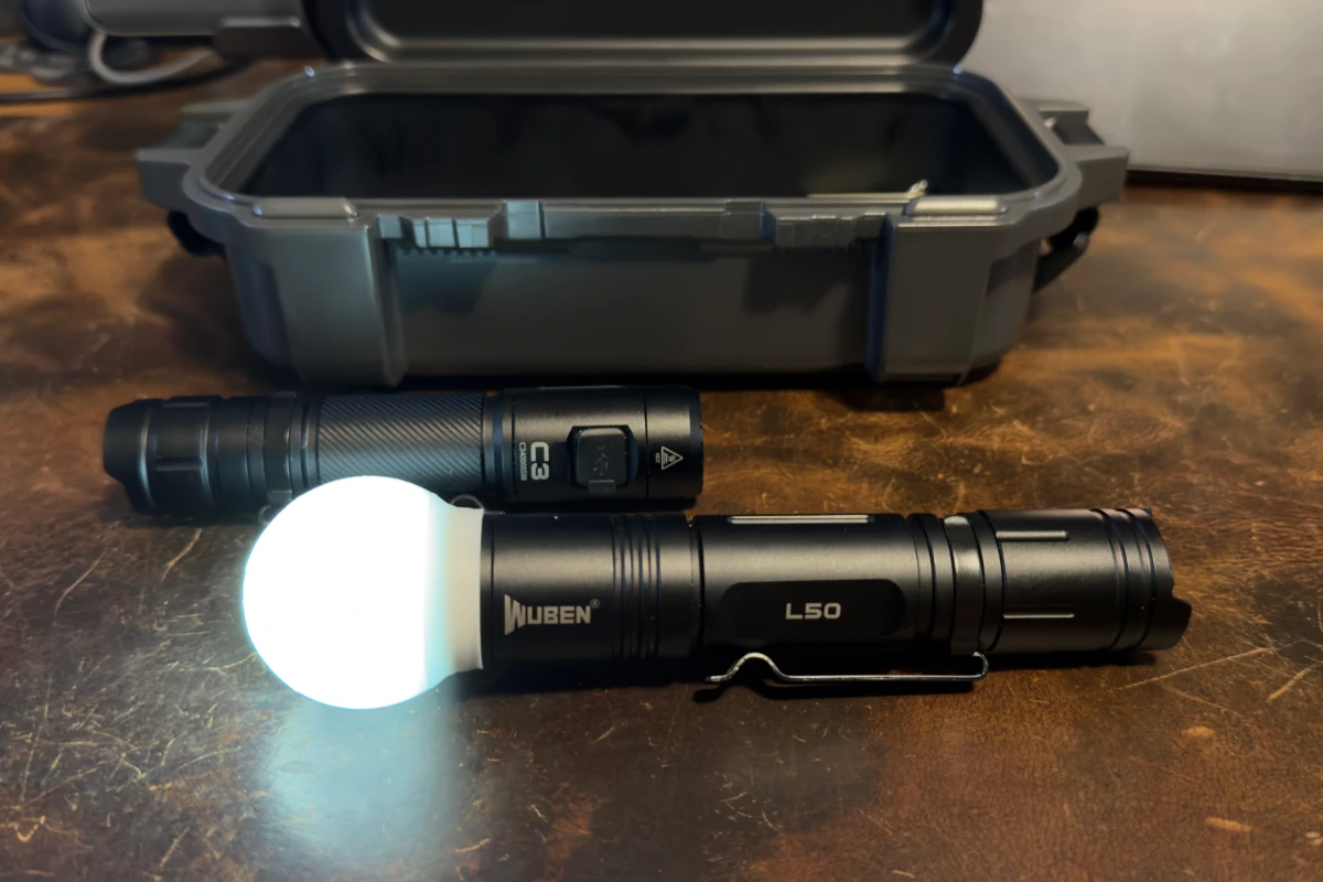 Wuben L50 flashlight with a 3D printed diffuser cap glowing as an ambient lantern next to a Wuben C3 and Yeti Gearbox